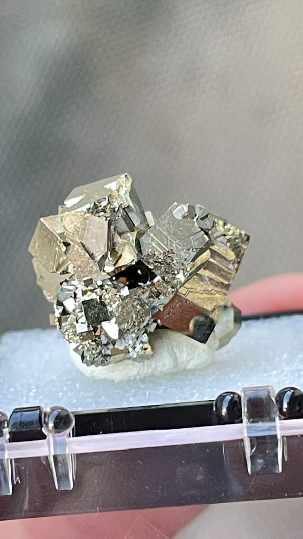 Bright brassy pyrite crystal cluster from Hubei, China, in a display box, top view