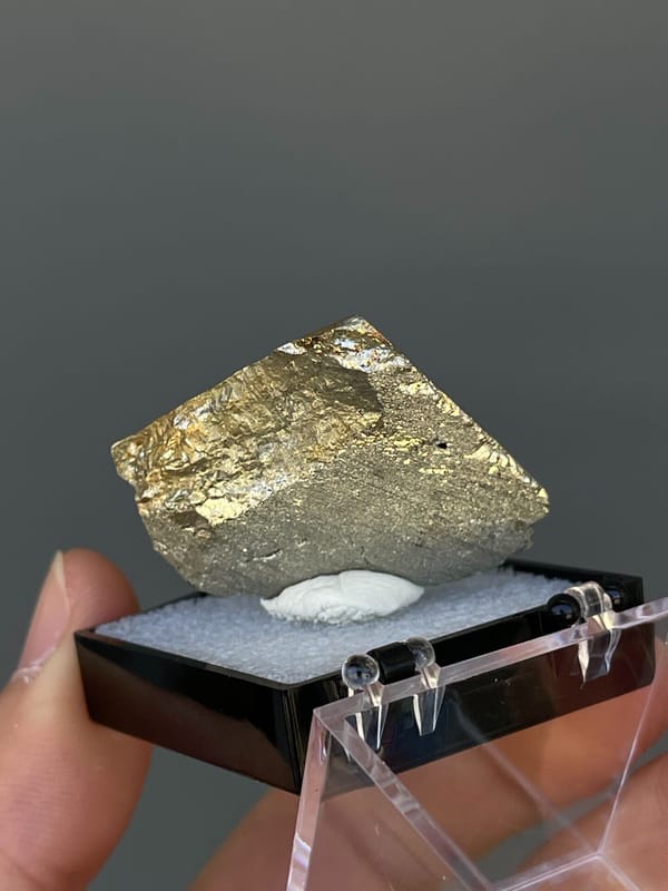 Brassy striated pyrite crystal from Yunnan, China, in a display box, top view