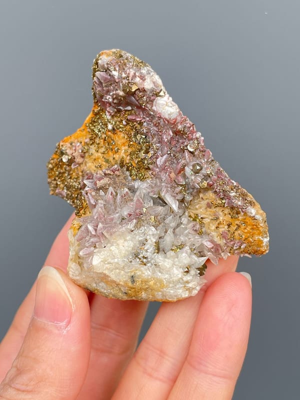 Golden pyrite crust over pale pink calcite from Hubei, China, close-up of the crystal faces