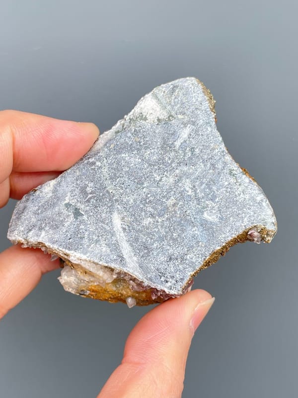 Golden pyrite crust over pale pink calcite from Hubei, China, detail of the matrix contact