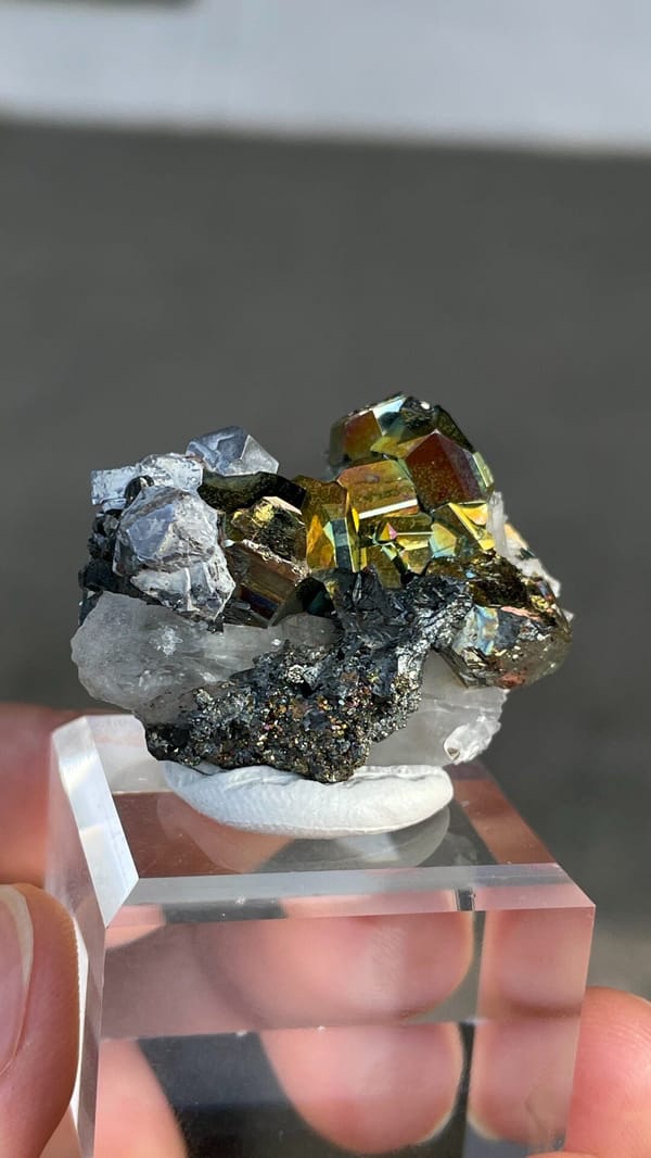 Iridescent pyrite crystals with grey galena from Peru, on an acrylic stand, second angle