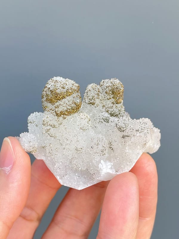 Golden pyrite crusting the tops of white quartz mounds from Fujian, China