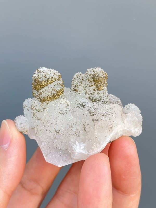 Golden pyrite crusting the tops of white quartz mounds from Fujian, China, second angle