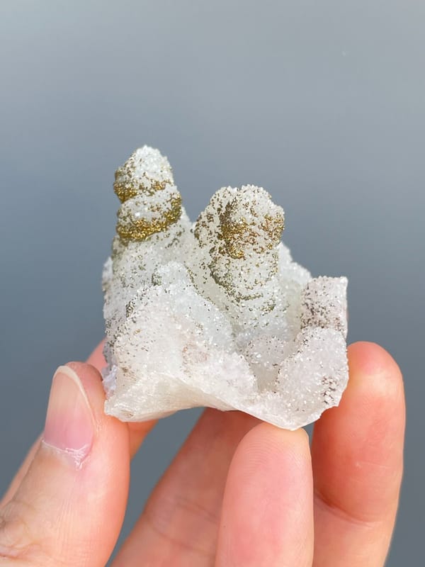 Golden pyrite crusting the tops of white quartz mounds from Fujian, China, close-up of the crystal faces