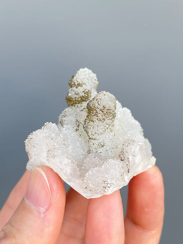 Golden pyrite crusting the tops of white quartz mounds from Fujian, China, reverse side