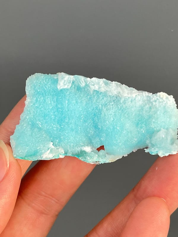 Turquoise-blue fibrous aragonite slab from Sichuan, China, detail of the matrix contact