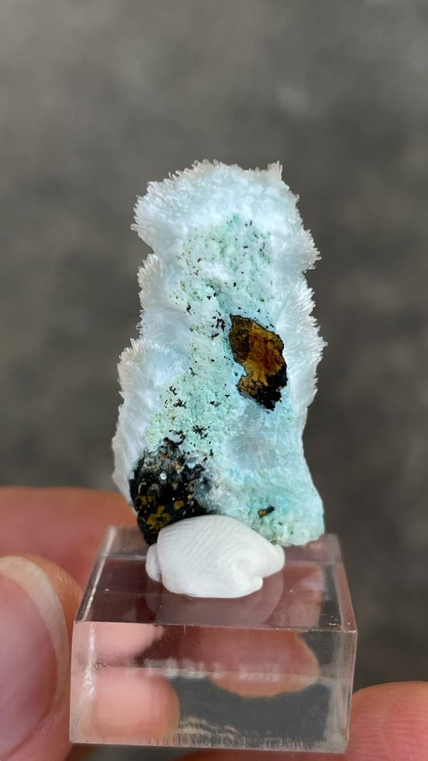 Sky-blue needle aragonite crust from Yunnan, China, on an acrylic stand, close-up of the crystal faces