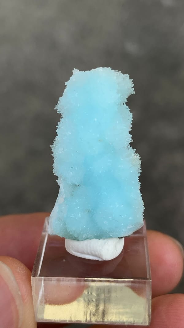 Sky-blue needle aragonite crust from Yunnan, China, on an acrylic stand, top view