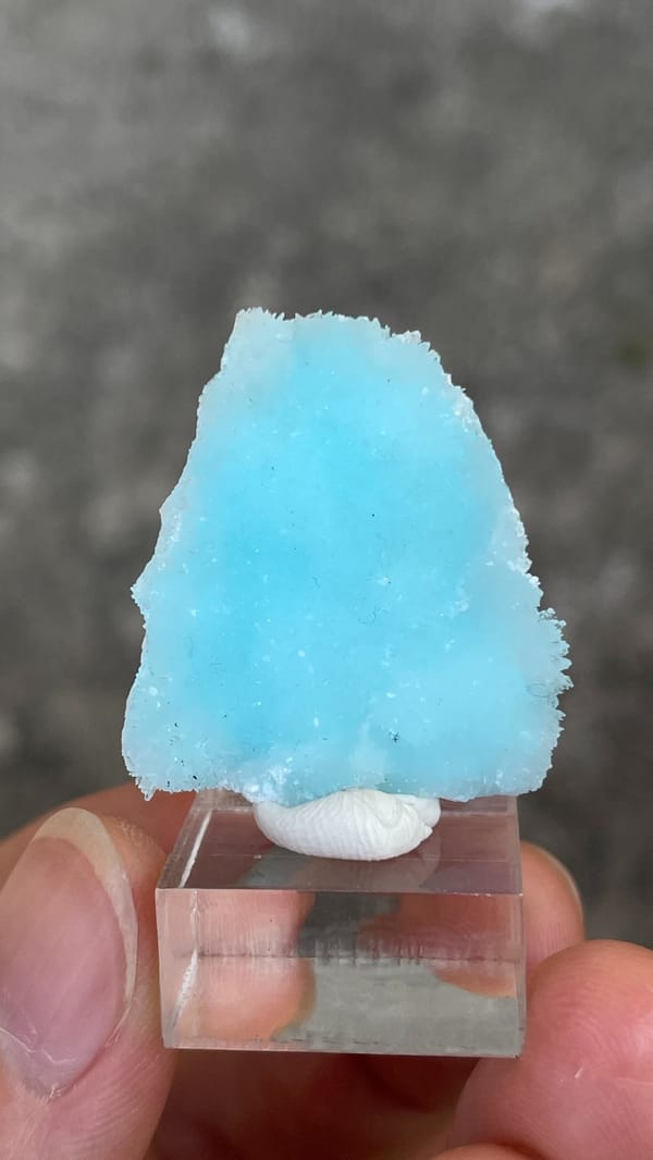 Sky-blue fibrous aragonite crust from Yunnan, China, on an acrylic stand
