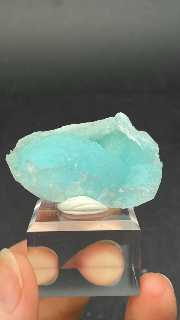 Turquoise-blue fibrous aragonite crust from Yunnan, China, on an acrylic stand