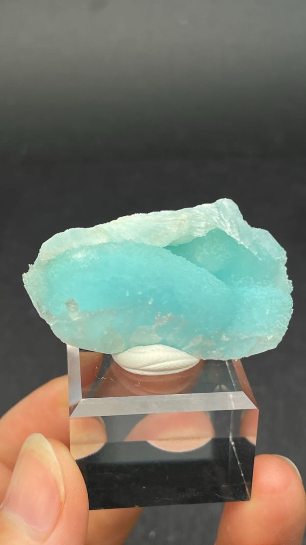 Turquoise-blue fibrous aragonite crust from Yunnan, China, on an acrylic stand, reverse side