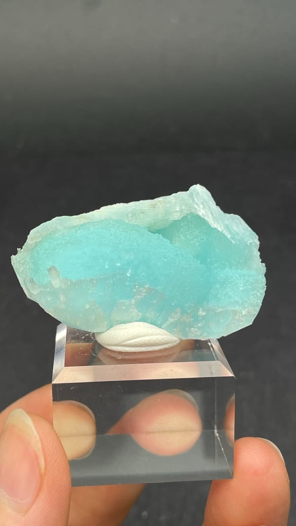 Turquoise-blue fibrous aragonite crust from Yunnan, China, on an acrylic stand, top view