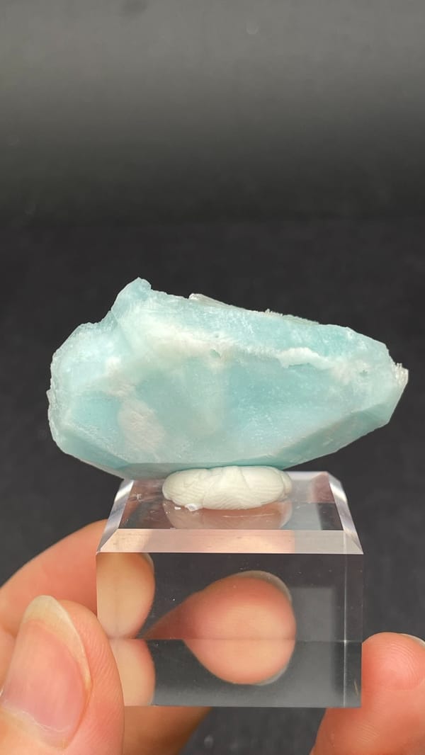 Turquoise-blue fibrous aragonite crust from Yunnan, China, on an acrylic stand, detail of the matrix contact