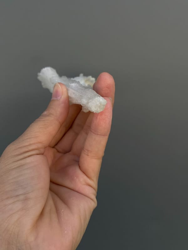 Long white fibrous aragonite fan from Guizhou, China, detail of the matrix contact