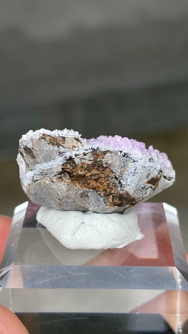 Magenta-pink aragonite cap on pale rock from Yunnan, China, detail of the matrix contact