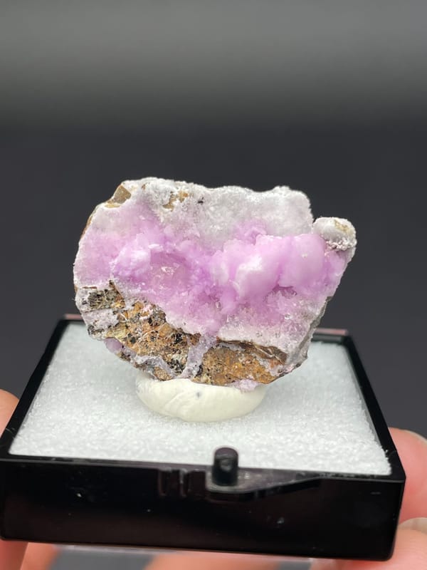 Pink-lilac botryoidal aragonite crust on pale slab from Yunnan, China, in a box