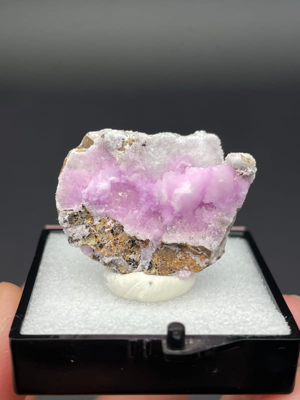 Pink-lilac botryoidal aragonite crust on pale slab from Yunnan, China, in a box, second angle