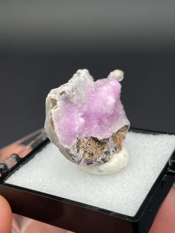 Pink-lilac botryoidal aragonite crust on pale slab from Yunnan, China, in a box, reverse side
