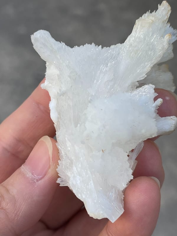 White fibrous aragonite spray from Guizhou, China, reverse side