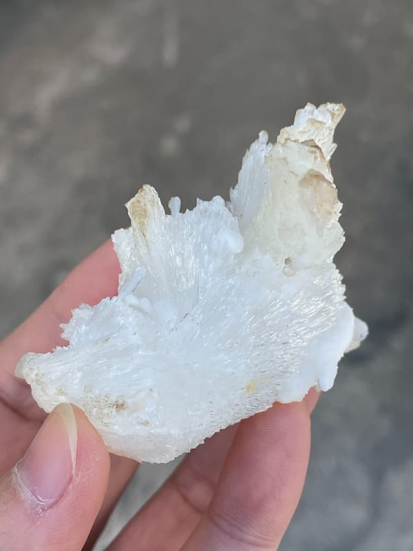White fibrous aragonite spray from Guizhou, China, detail of the matrix contact