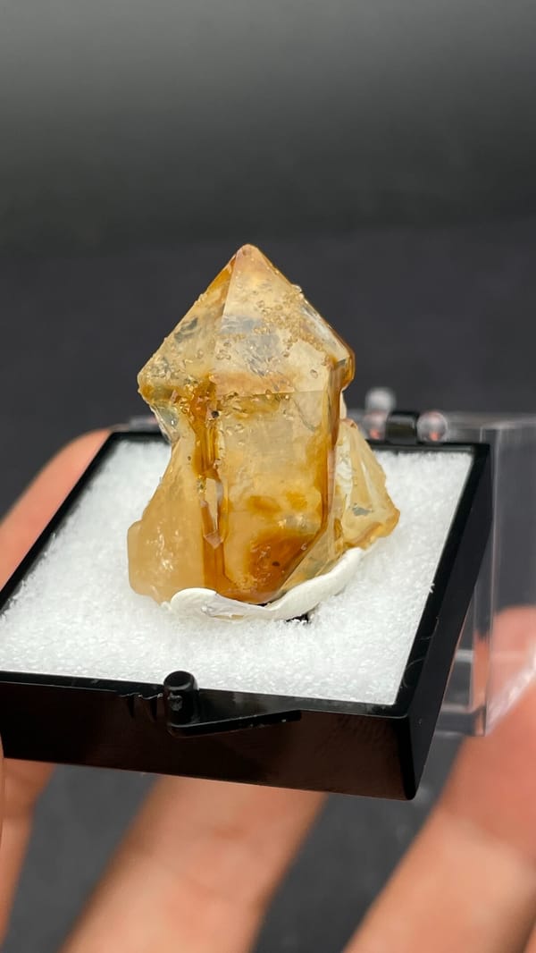 Amber caramel-coloured quartz crystal from Guangdong, China, in a display box