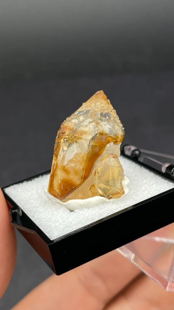 Amber caramel-coloured quartz crystal from Guangdong, China, in a display box, second angle