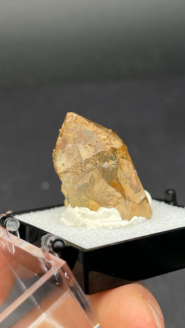 Amber caramel-coloured quartz crystal from Guangdong, China, in a display box, reverse side