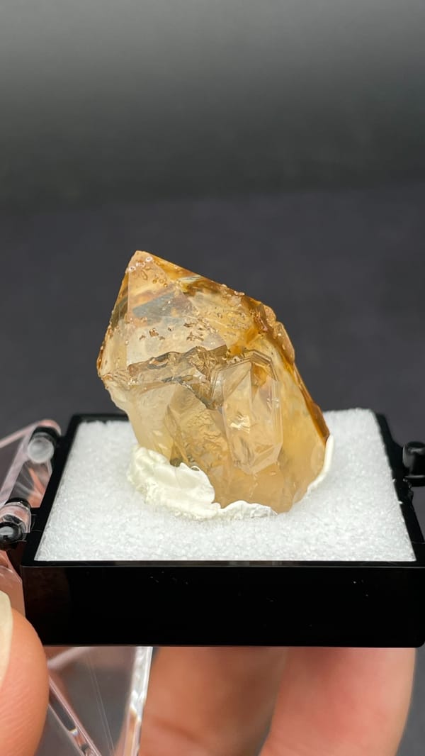 Amber caramel-coloured quartz crystal from Guangdong, China, in a display box, top view