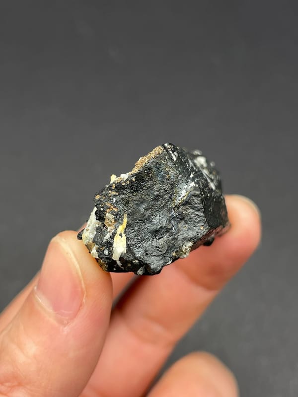 Black prismatic crystal crossed by white quartz from Inner Mongolia, China, detail of the matrix contact