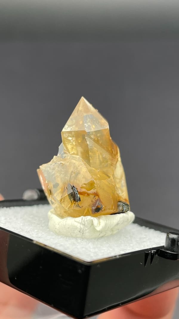 Caramel-brown transparent quartz crystal from Guangdong, China, in a display box