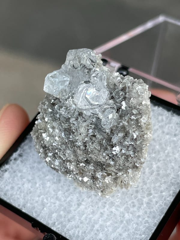 Pale blue aquamarine crystals on a dark mica bed, Xuebaoding, Sichuan, China
