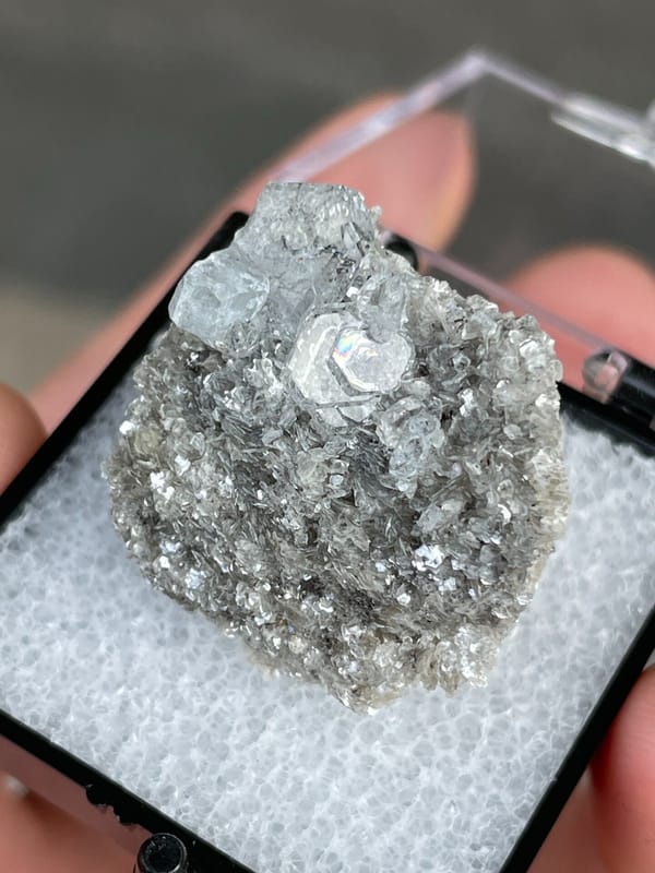 Pale blue aquamarine crystals on a dark mica bed, Xuebaoding, Sichuan, China, detail of the matrix contact