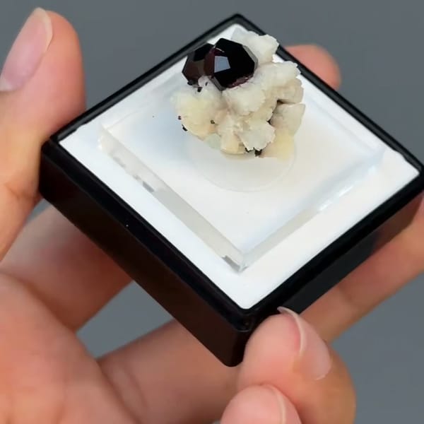 Dark red spessartine garnet crystals on white feldspar from Fujian — alternate view