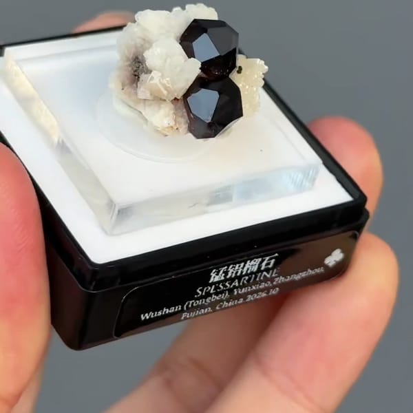 Dark red spessartine garnet crystals on white feldspar from Fujian — detail view