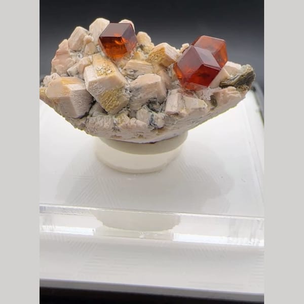 Orange-red spessartine garnet crystals on pale feldspar matrix from Yunxiao, Fujian, China — alternate view