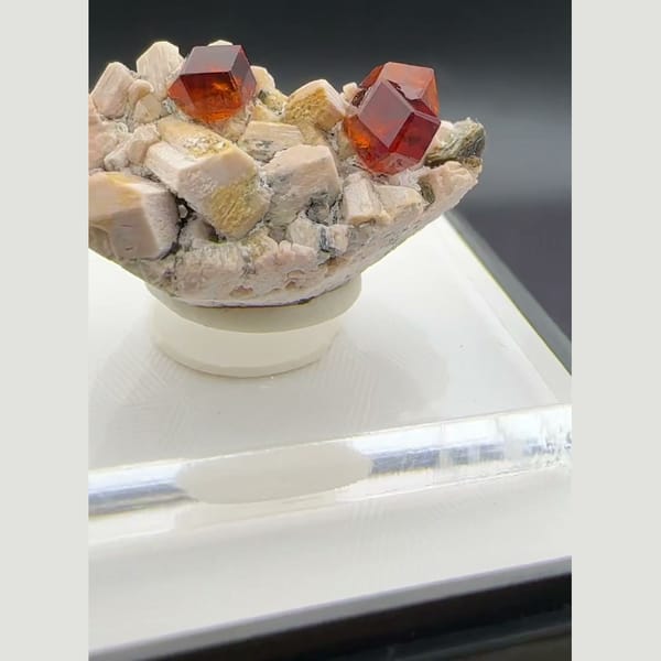 Orange-red spessartine garnet crystals on pale feldspar matrix from Yunxiao, Fujian, China — alternate view