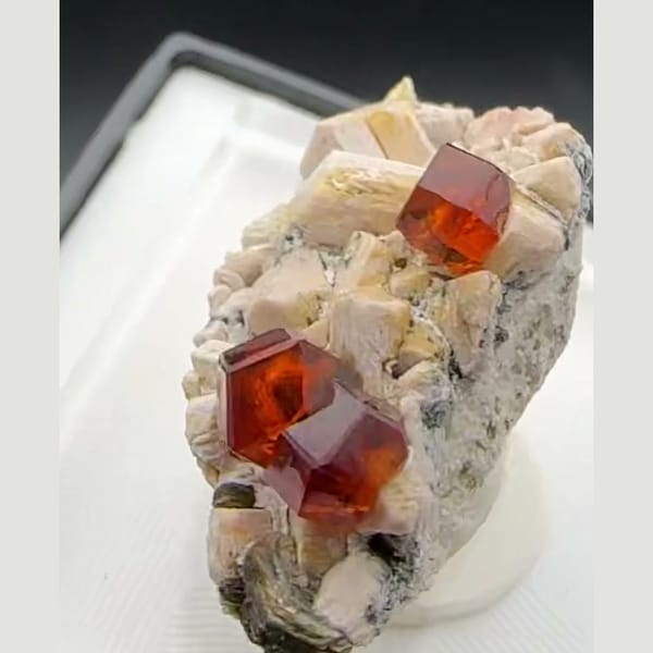 Orange-red spessartine garnet crystals on pale feldspar matrix from Yunxiao, Fujian, China — detail view