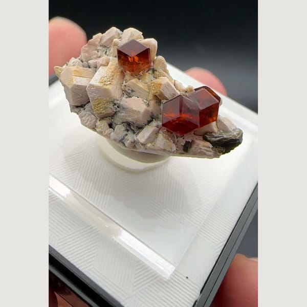 Orange-red spessartine garnet crystals on pale feldspar matrix from Yunxiao, Fujian, China — detail view