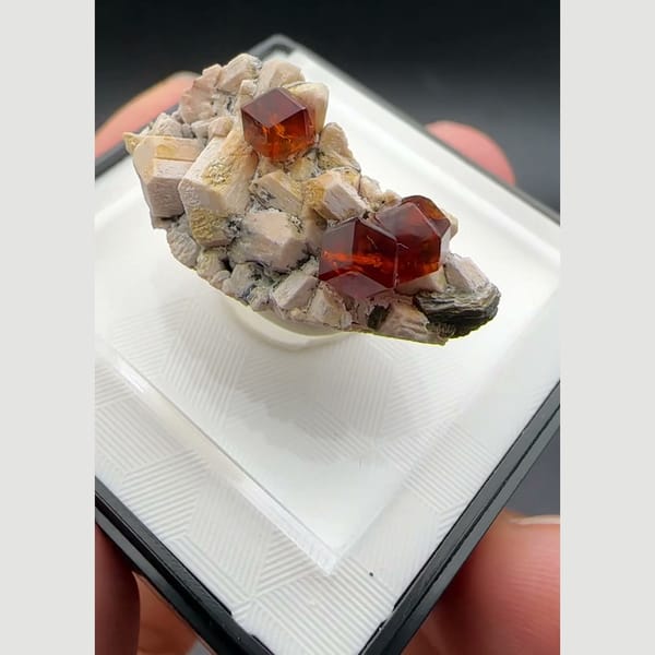 Orange-red spessartine garnet crystals on pale feldspar matrix from Yunxiao, Fujian, China — detail view