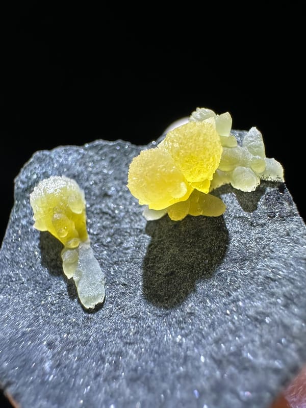 Yellow calcite cluster with pale extensions on dark matrix from Zhejiang China, specimen view 1