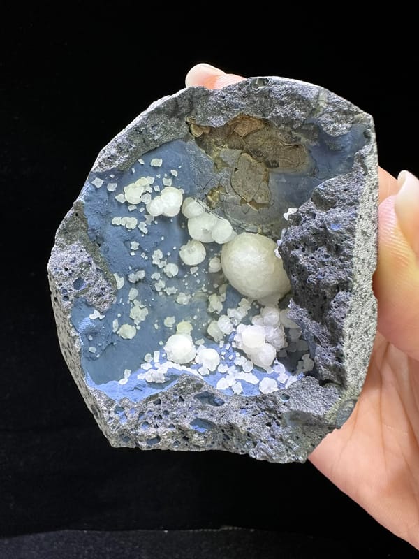White calcite spheres lining a blue-gray cavity from Zhejiang China, specimen view 1