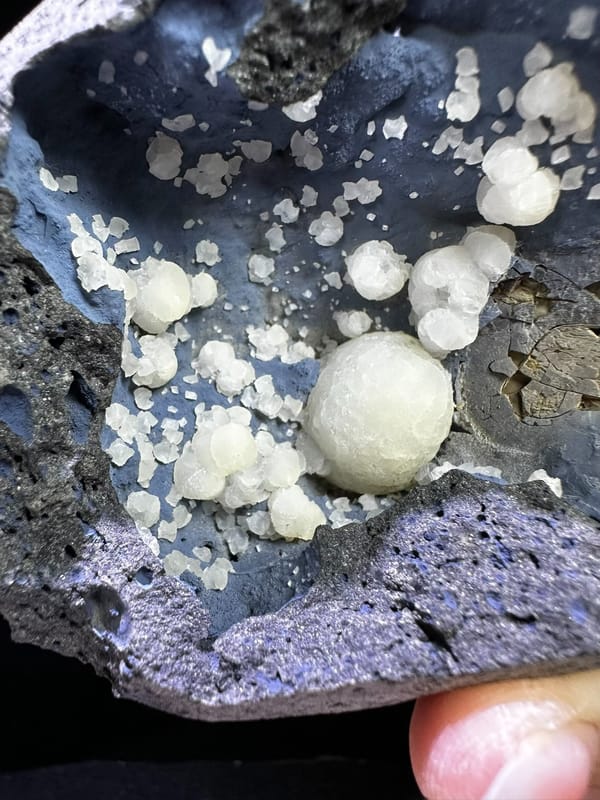 White calcite spheres lining a blue-gray cavity from Zhejiang China, specimen view 2