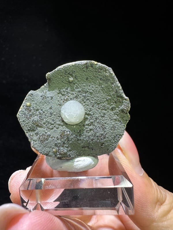 White calcite sphere on textured gray-green matrix from Zhejiang China, specimen view 1