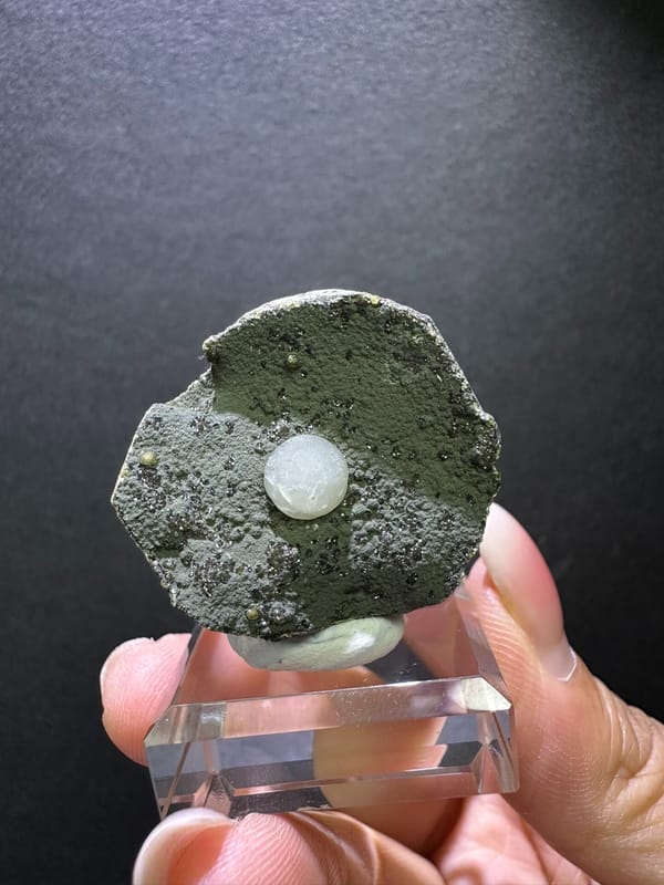 White calcite sphere on textured gray-green matrix from Zhejiang China, specimen view 2