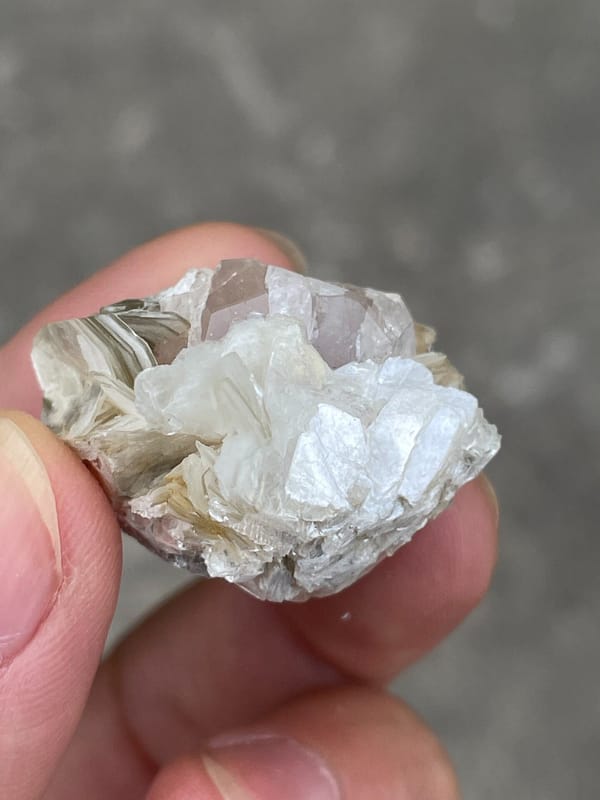 Pale pink apatite crystal surrounded by white mica blades from Pakistan, reverse side
