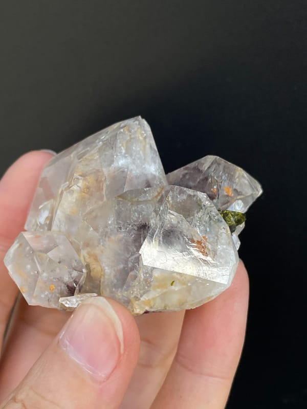Clear garden quartz with green epidote inclusions from Meigu, Sichuan, China, close-up of the crystal faces