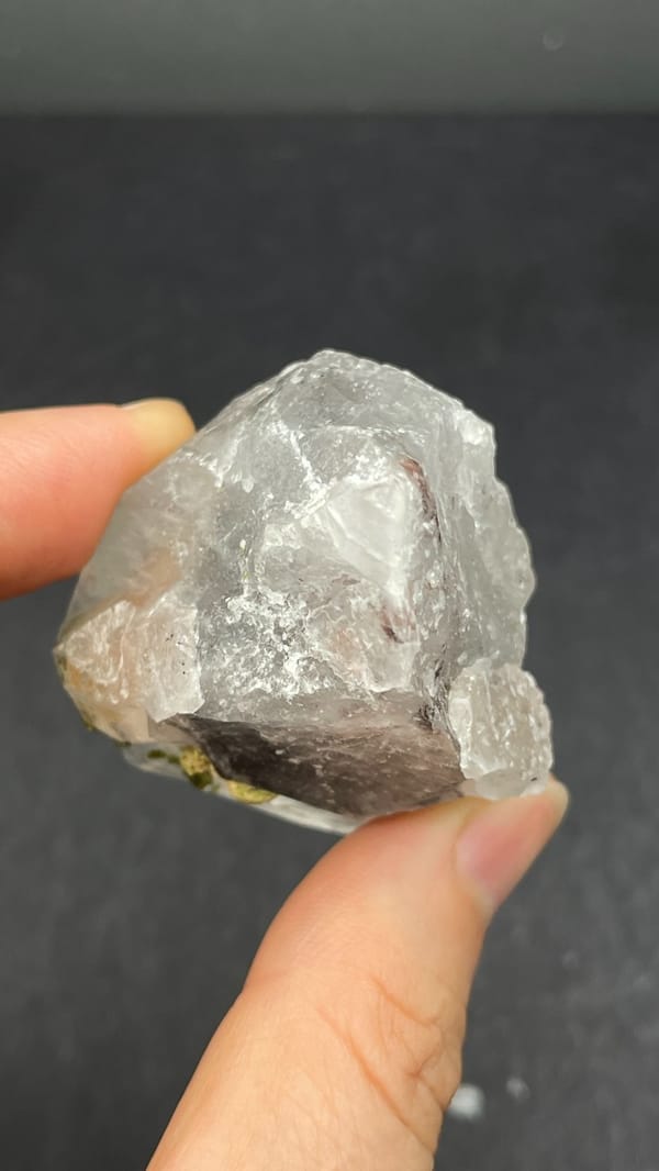 Large garden quartz crystal with epidote inclusions from Meigu, Sichuan, China, detail of the matrix contact