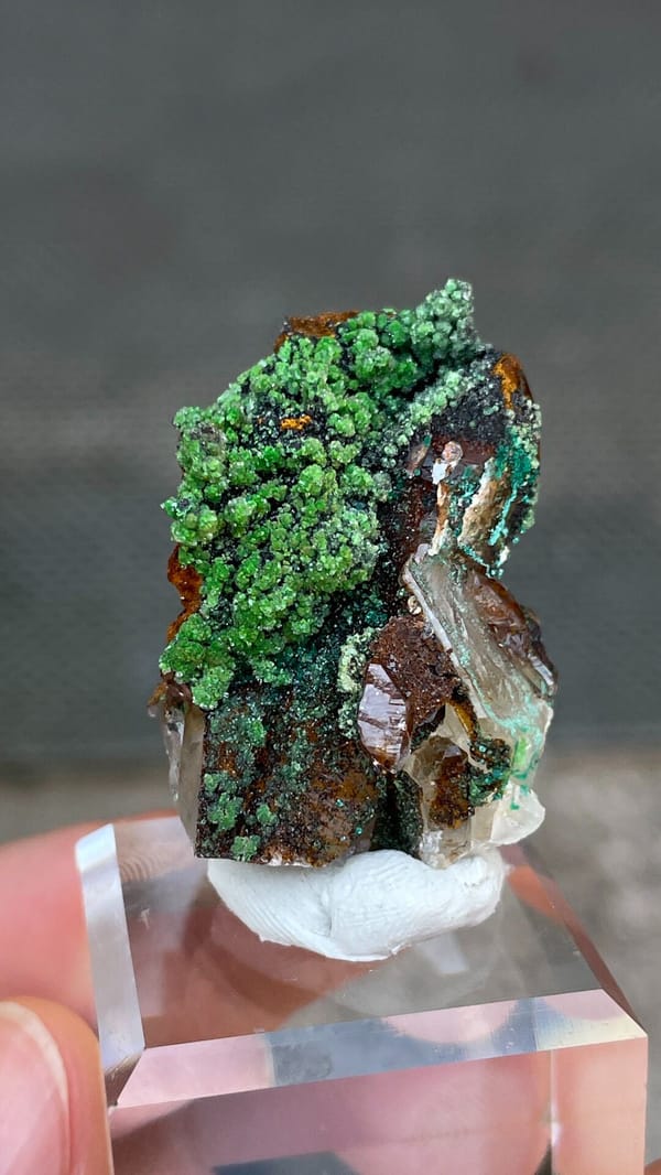 Grass-green conichalcite balls on quartz and matrix from Morocco, close-up of the crystal faces