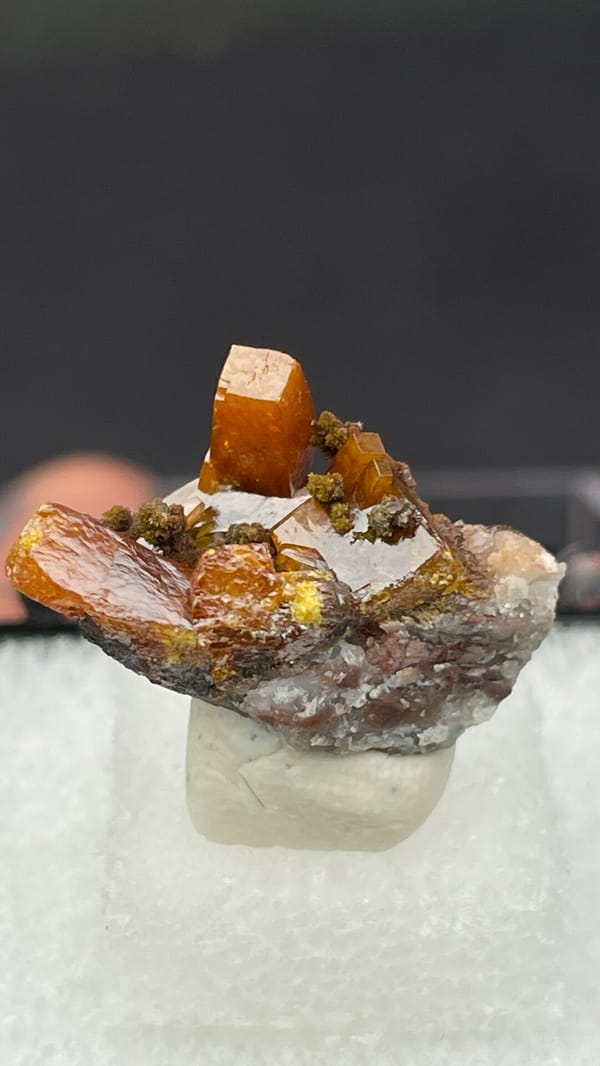 Bright orange wulfenite crystals on brown matrix from Mexico, in a display box, second angle