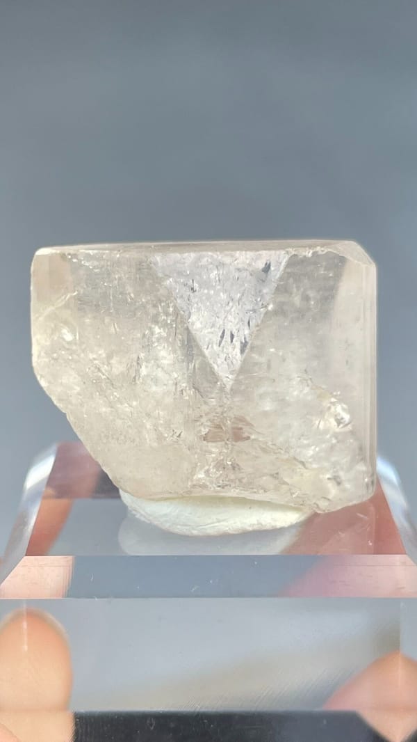 Colourless blocky topaz crystal from Yunnan, China, on an acrylic stand